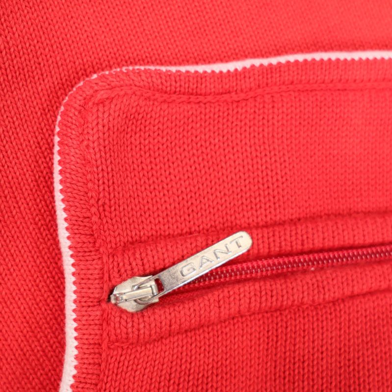 Närbild på röd dragkedja med GANT-dragare