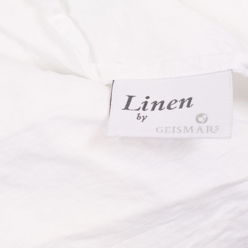 Närbild på vit etikett märkt Linen by Geismars