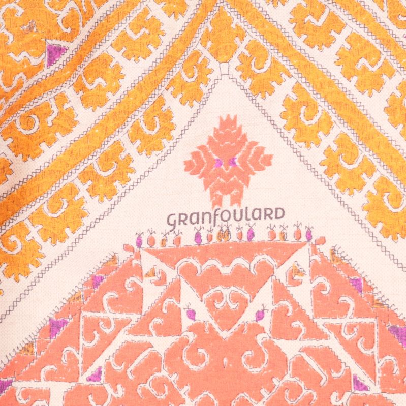Närbild av Granfoulard-logga på mönstrat tyg