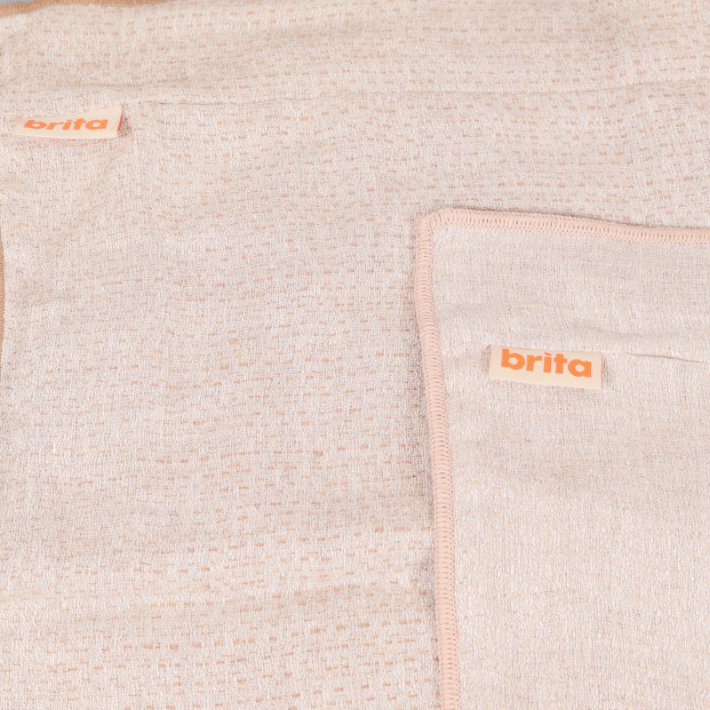 Närbild på Brita-logotyper och småmönstrad ljus textilväv