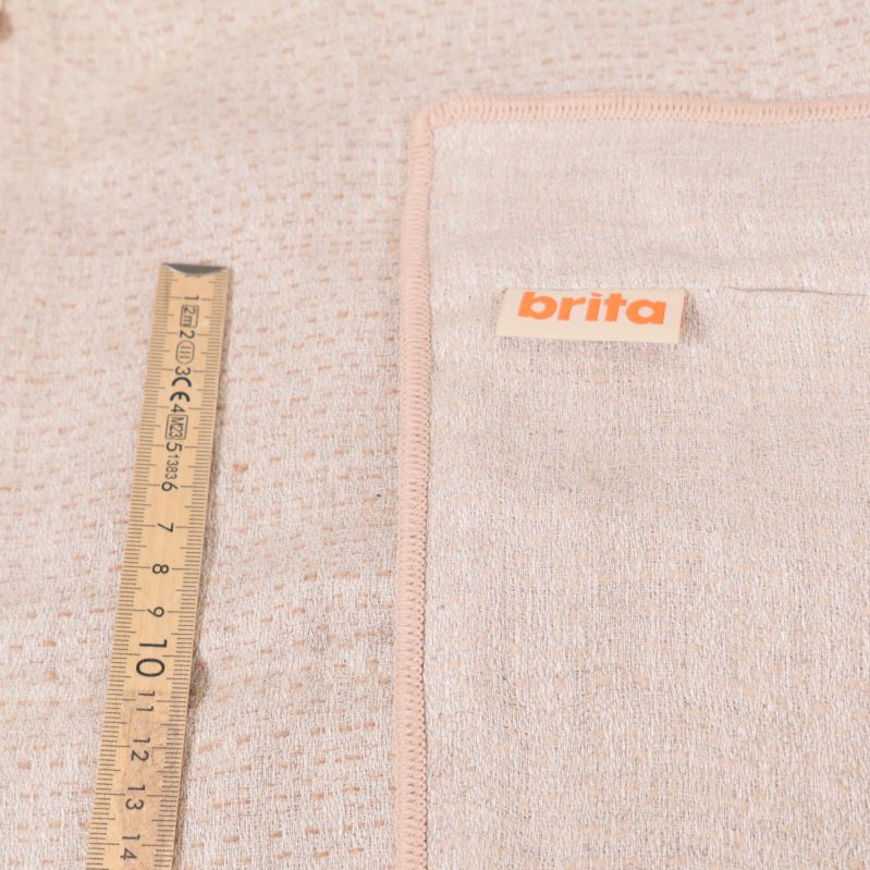 Måttband intill ljus Brita-textil med rosa kantband