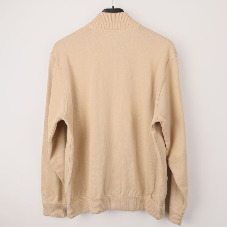 Baksidan av beige tröja med ribbade kanter