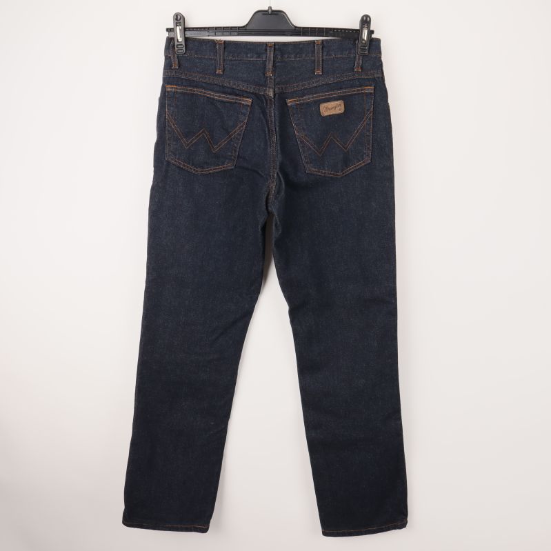 Bakre vy av mörkblå jeans med bakfickor och märke