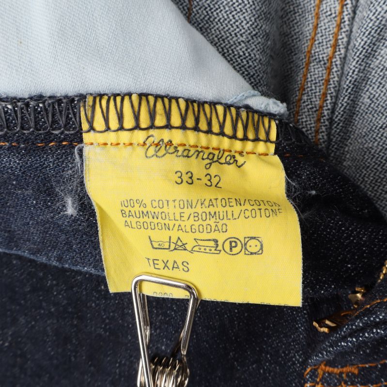 Jeans etikett som visar bomullsprocent och storlek