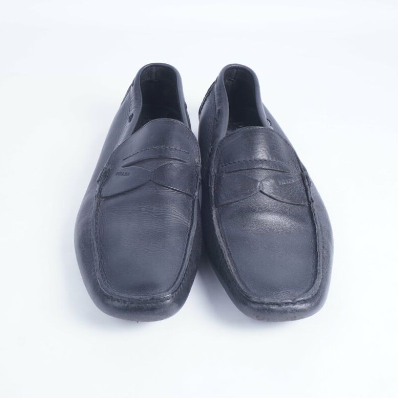 Framsidan av svarta loafers