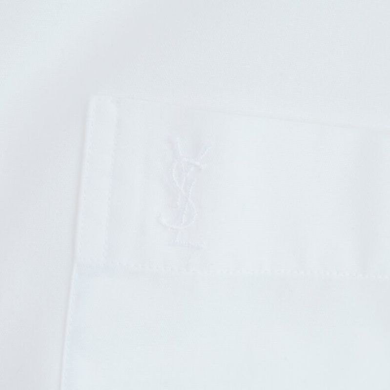 Närbild av YSL-logo på bröstfickan