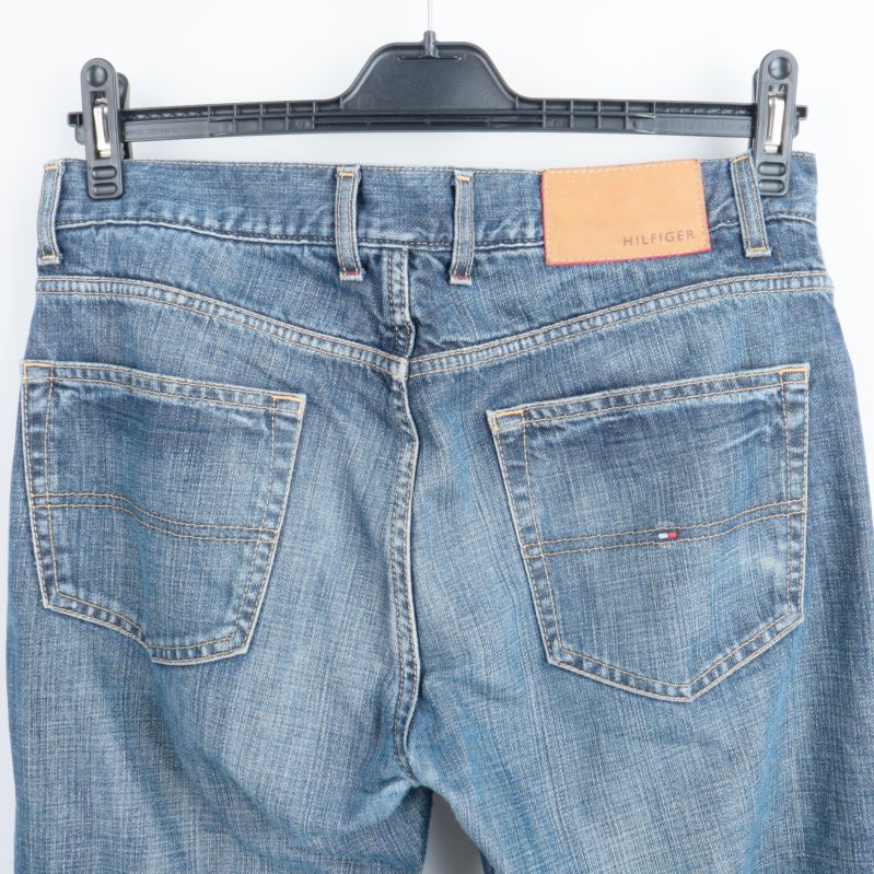 Bakfickor av blå jeans med logotyp