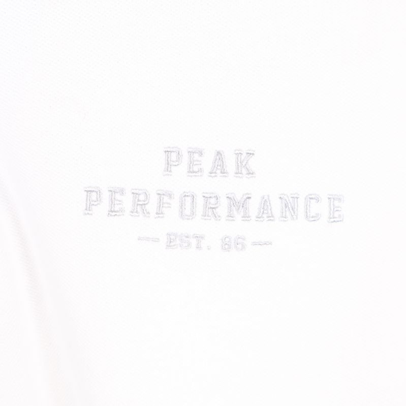 Broderad text på bröstet 'Peak Performance'