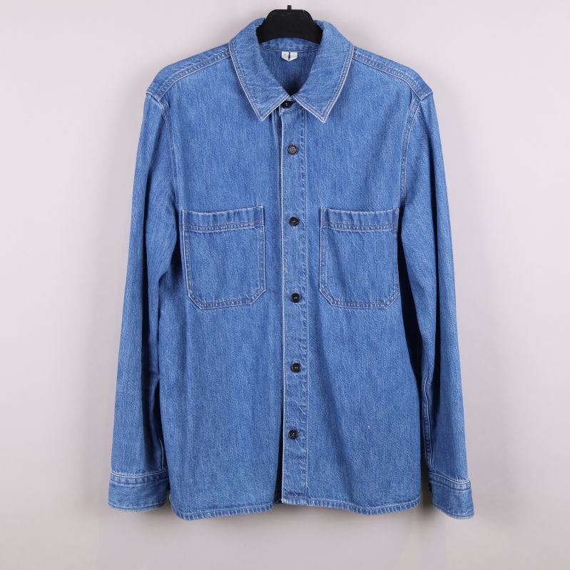 Framsida av blå denimskjorta med fickor