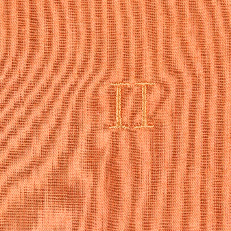 Närbild på broderat emblem på skjortan