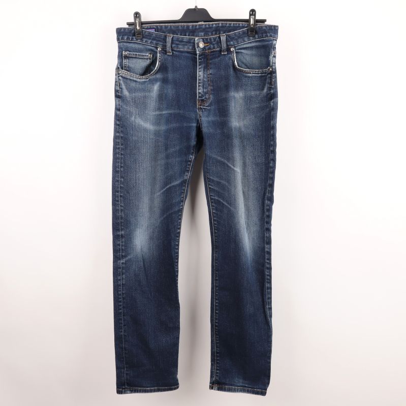 Framsidan av blå jeans med tvättad effekt