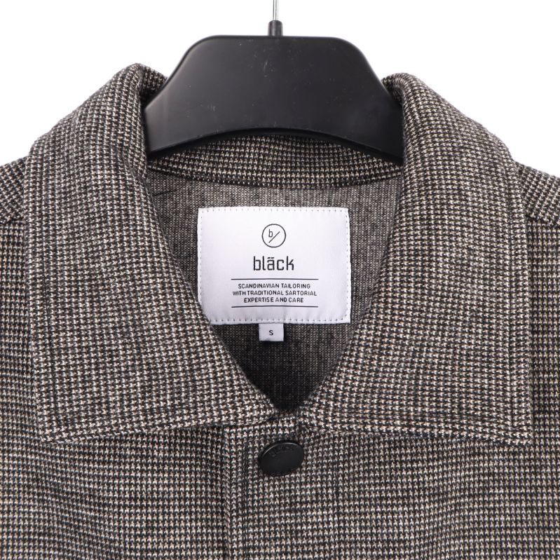 Närbild på skjortans etikett med märket: Bläck