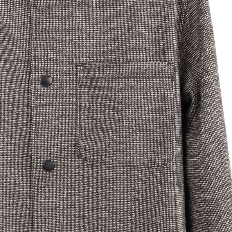 Detaljbild av skjortans bröstficka och knapp