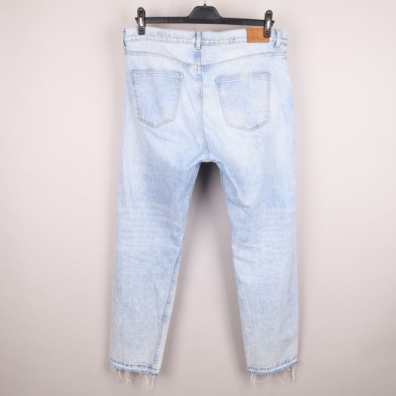 Baksida av ljusa jeans med två bakfickor