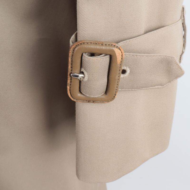 Närbild av ärmspänne på trenchcoaten