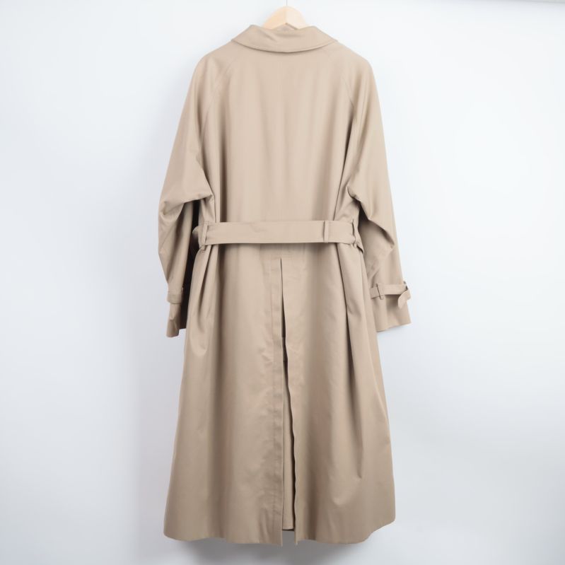 Baksidan av beige trenchcoat med bälte