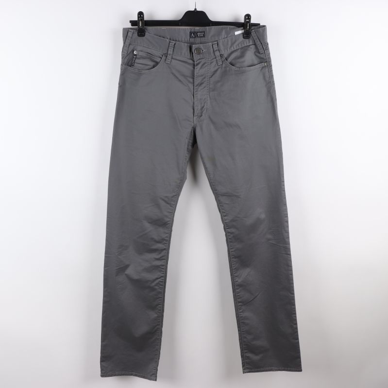 Framsidan av grå jeans med knäppning och fickor