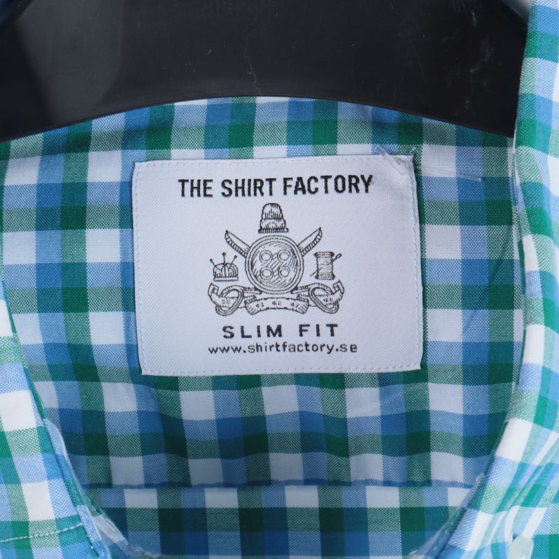 Etikett på skjorta med texten: The Shirt Factory