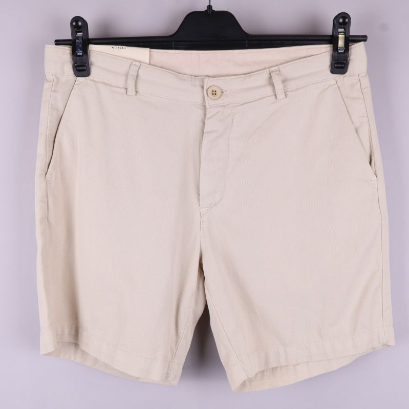 Framsida av beige chinoshorts