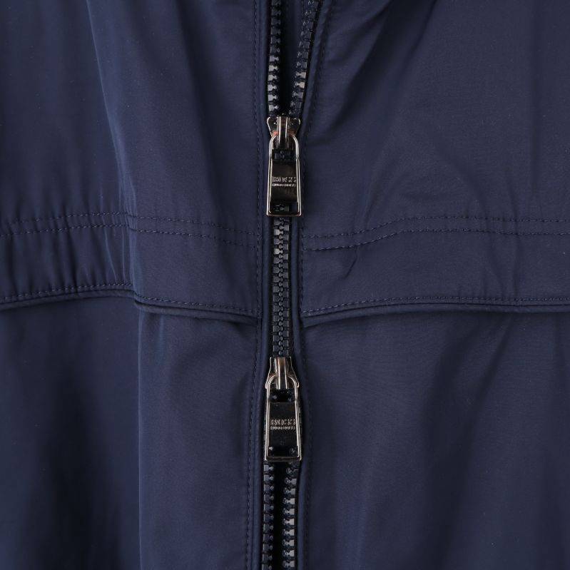 Närbild på dragkedja på marinblå jacka