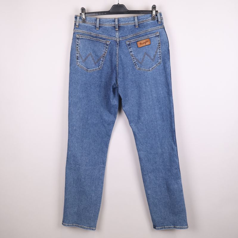 Baksida av blå jeans på galge