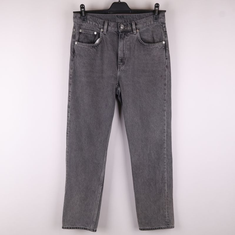 Framsidan av grå jeans 
