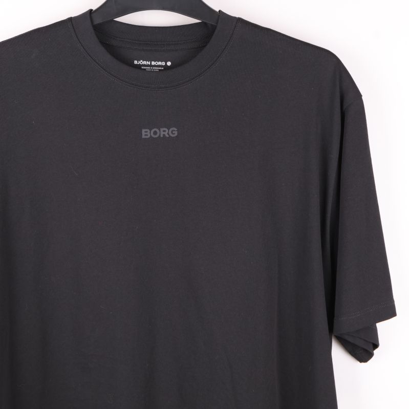 Närbild på bröstet på svart t-shirt med logotryck