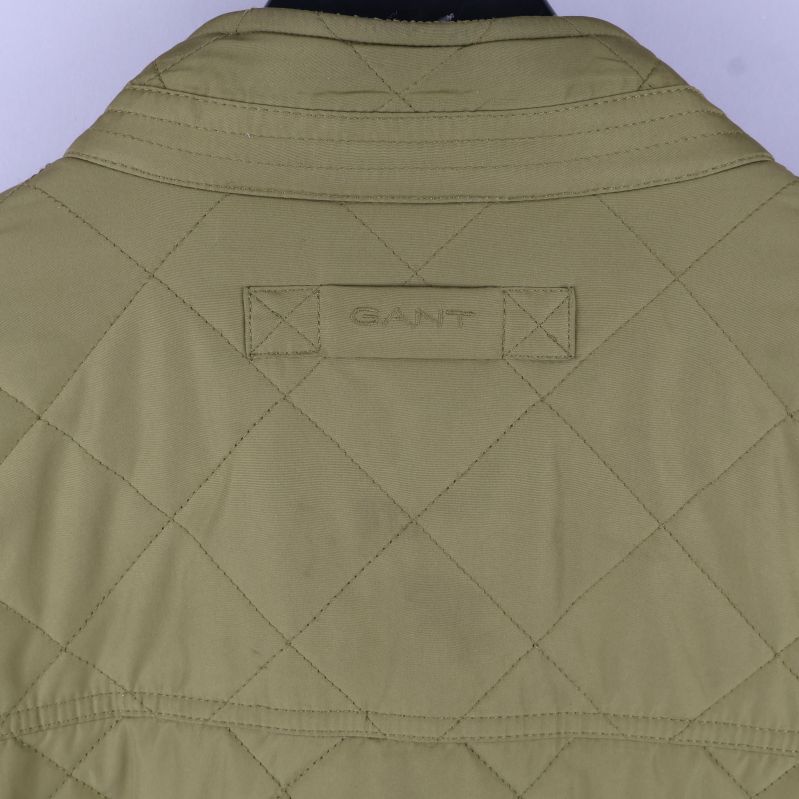 Detaljvy av broderad logga på jackan