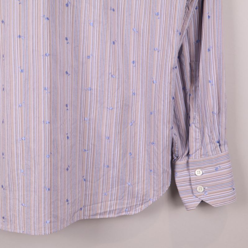 Närbild på skjortans manschett med knapp