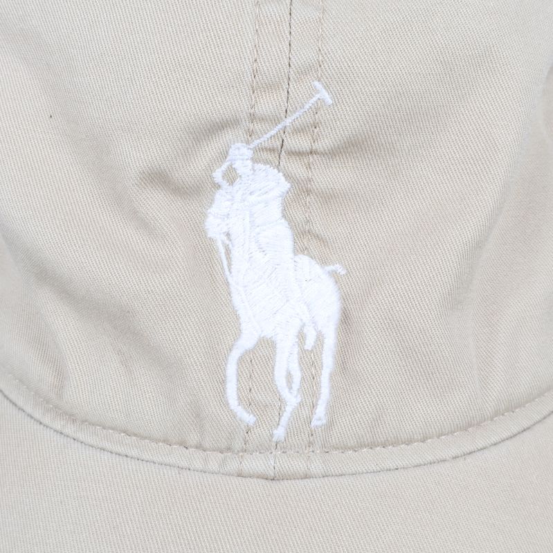 Närbild av vit broderad logo på keps