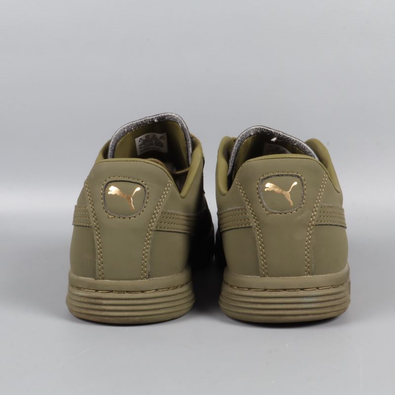 Sneakers bakifrån med guldfärgad logga på hälen