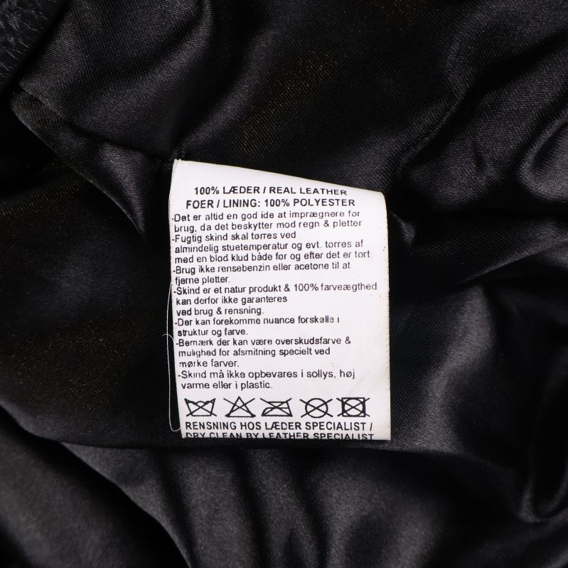 Materiallapp i jackan som visar 100% läder och fodret av polyester