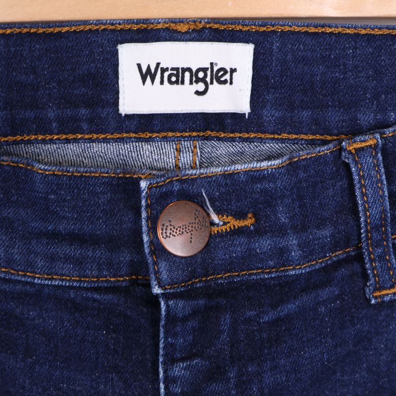Wrangler logotypetikett och knapp framtill vid midjan