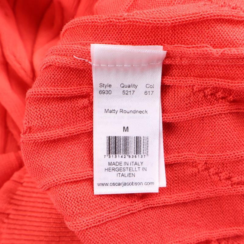 Textiletikett med modell och färgkod på insidan av tröjan
