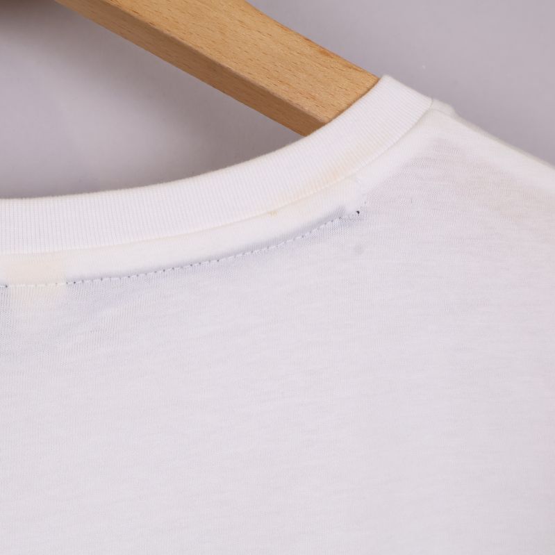 Närbild på halsringningens söm på vit t-shirt