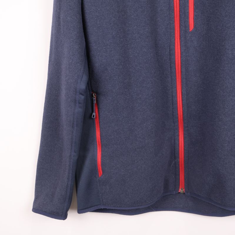 Närbild på nedre del av jacka med röda fickdragkedjor