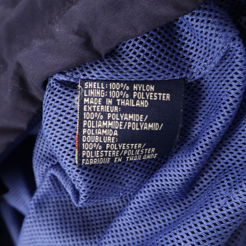 Materialetikett visar 100% nylon och polyesterfoder