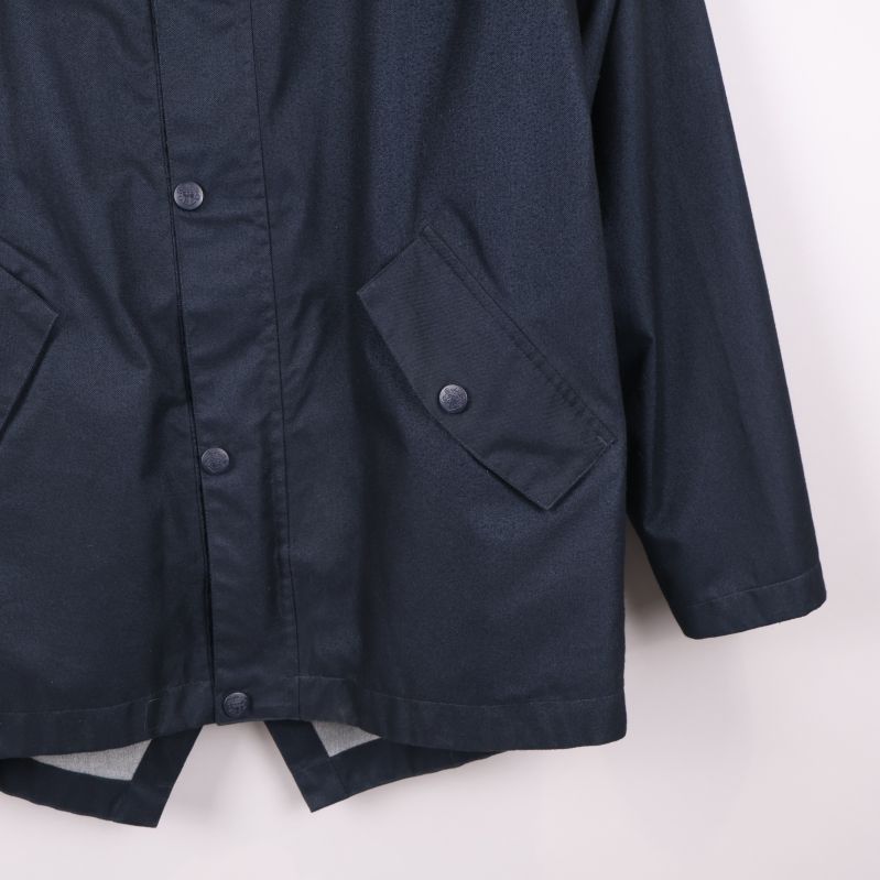 Ytterligare närbild på jackans ficka och knappdetalj