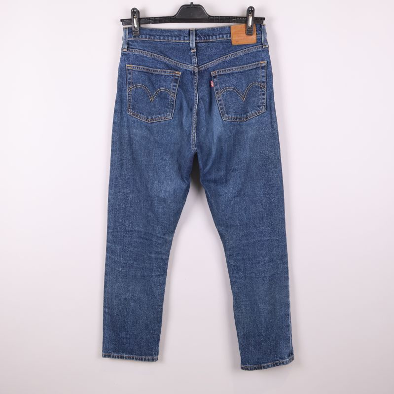 Baksida av blå jeans med synliga fickor och patch