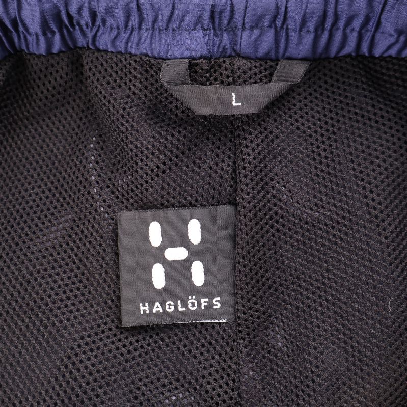 Etikett med Haglöfs logotyp och storlek L på byxan