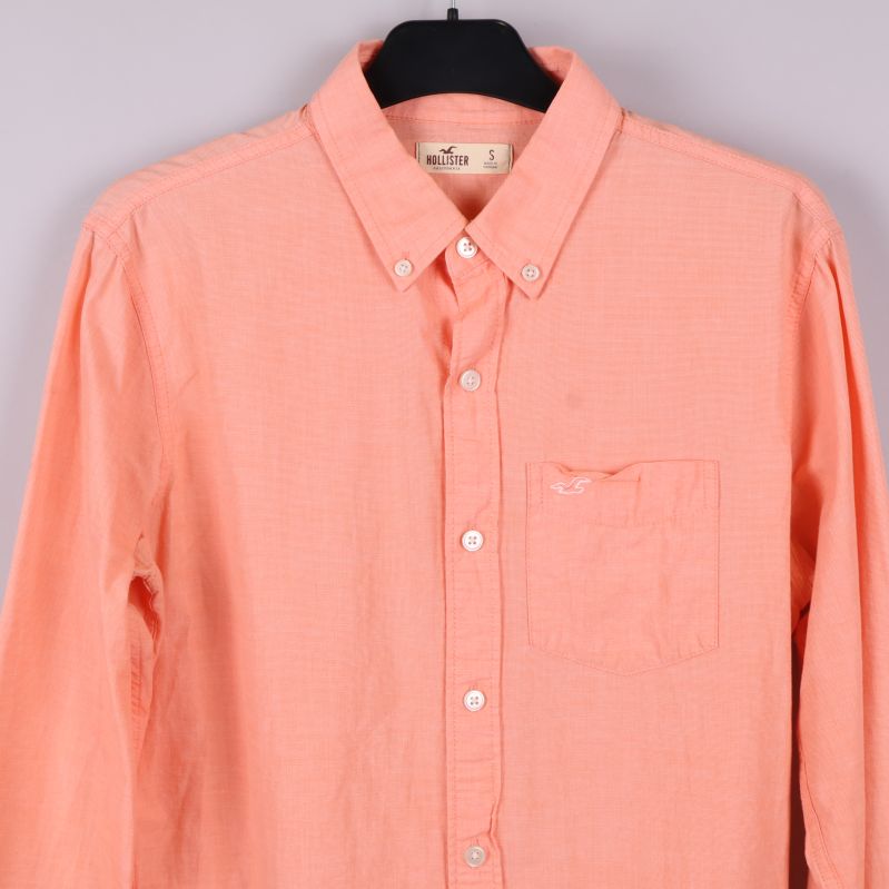 Framsida upptill på aprikos skjorta med bröstficka