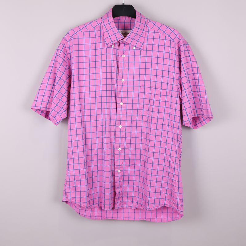 Kortärmad rosa skjorta med blåa rutor hängande på galge