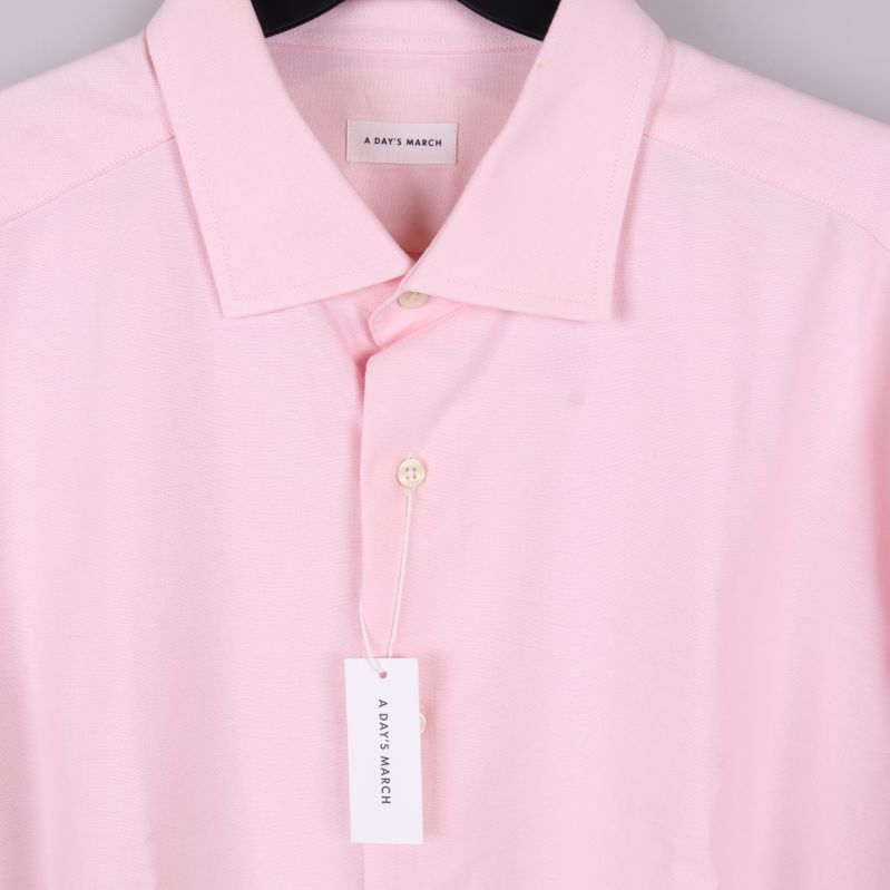 Detalj av skjortkrage med vit etikett och knapp