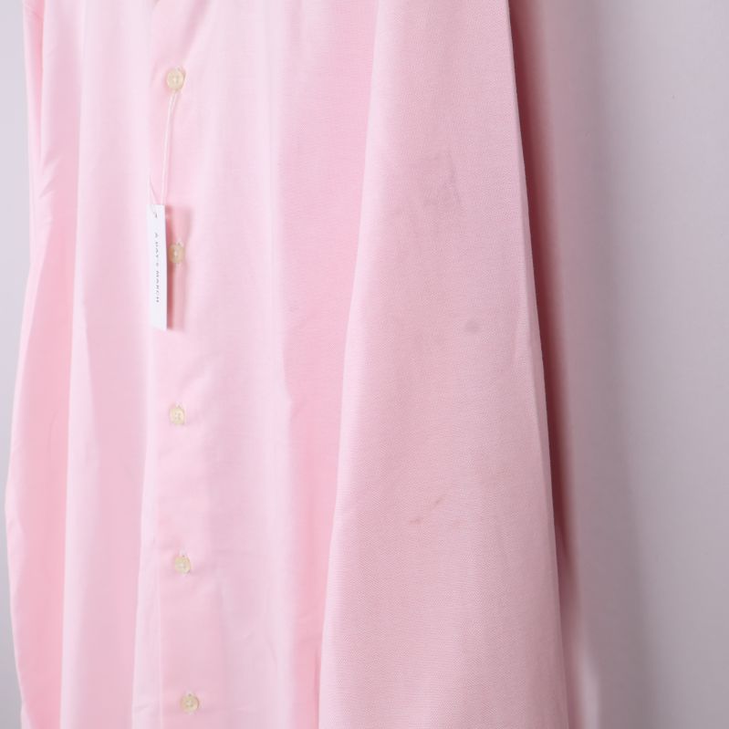 Närbild på ärm med svag fläck på ljusrosa tyg