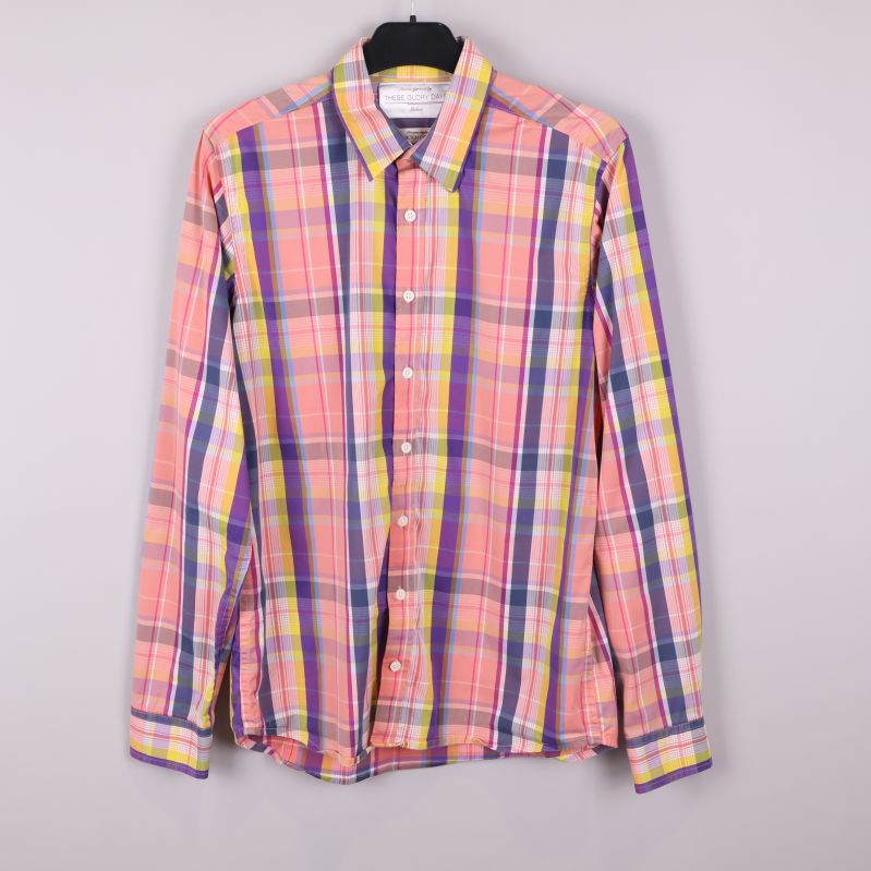 Färgglad rutig skjorta hängande mot ljus bakgrund