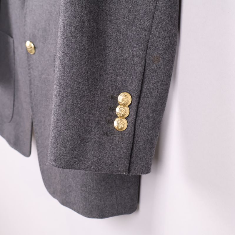 Ärmslut med tre guldfärgade knappar på kavajen