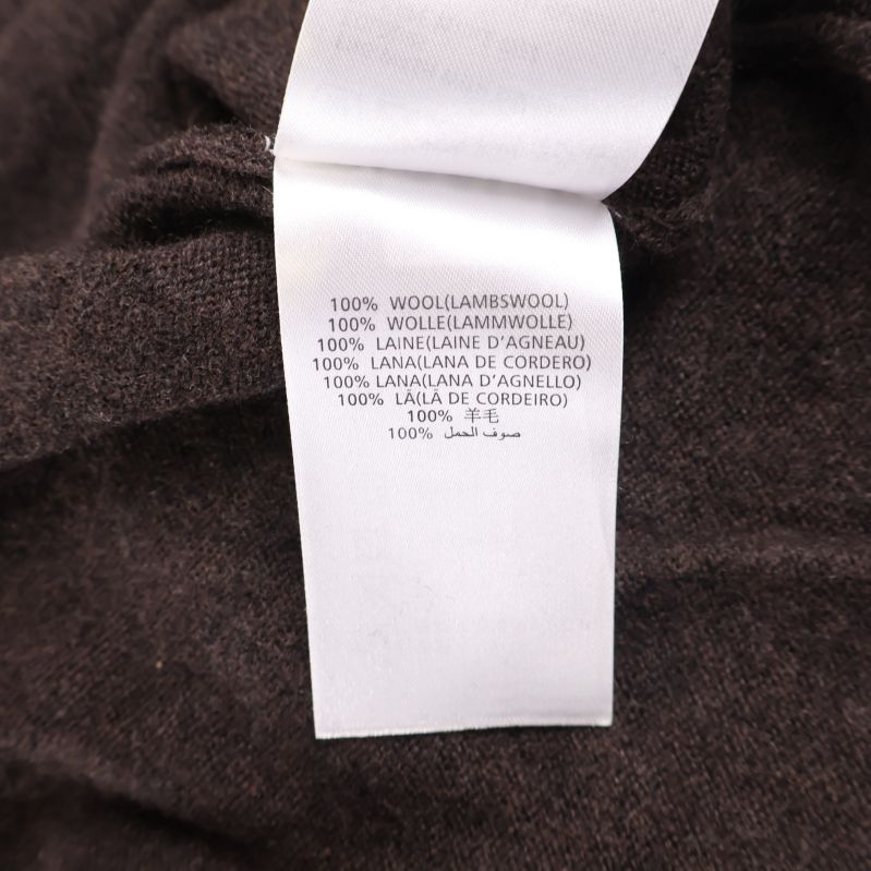 Materiallapp med texten 100% wool lammull på brun tröja