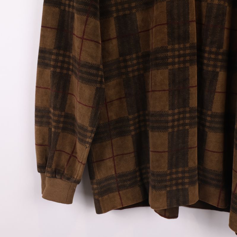 Mudd på ärmslut av rutiga tröjan visas i närbild