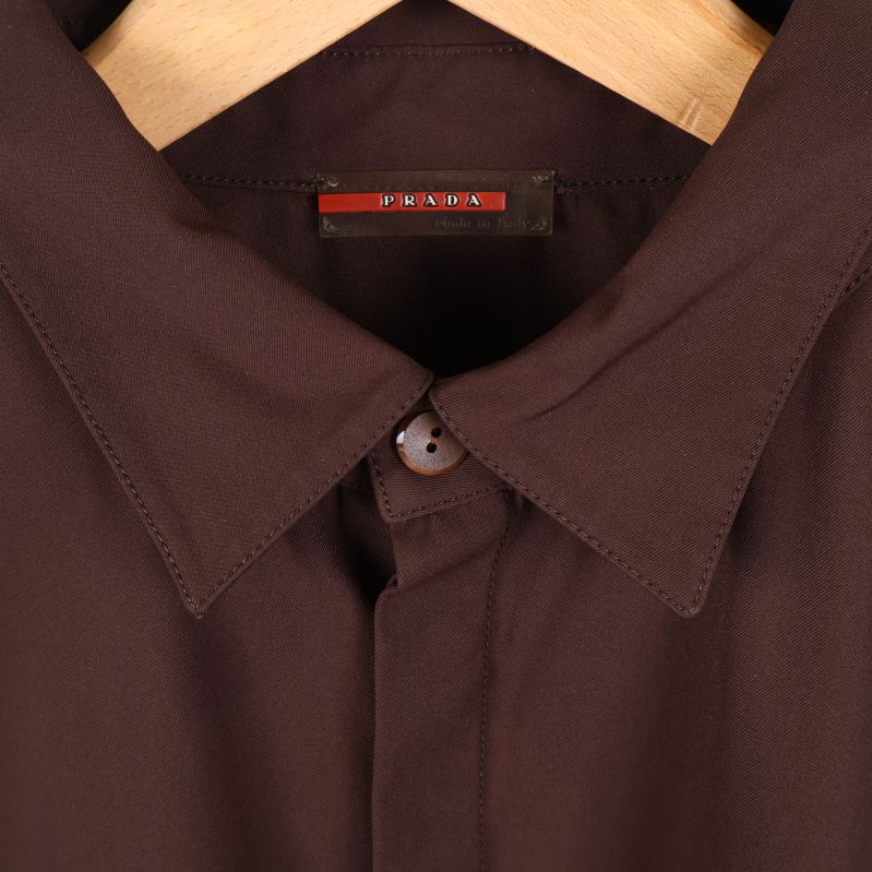 Närbild av skjortkrage med Prada-logga