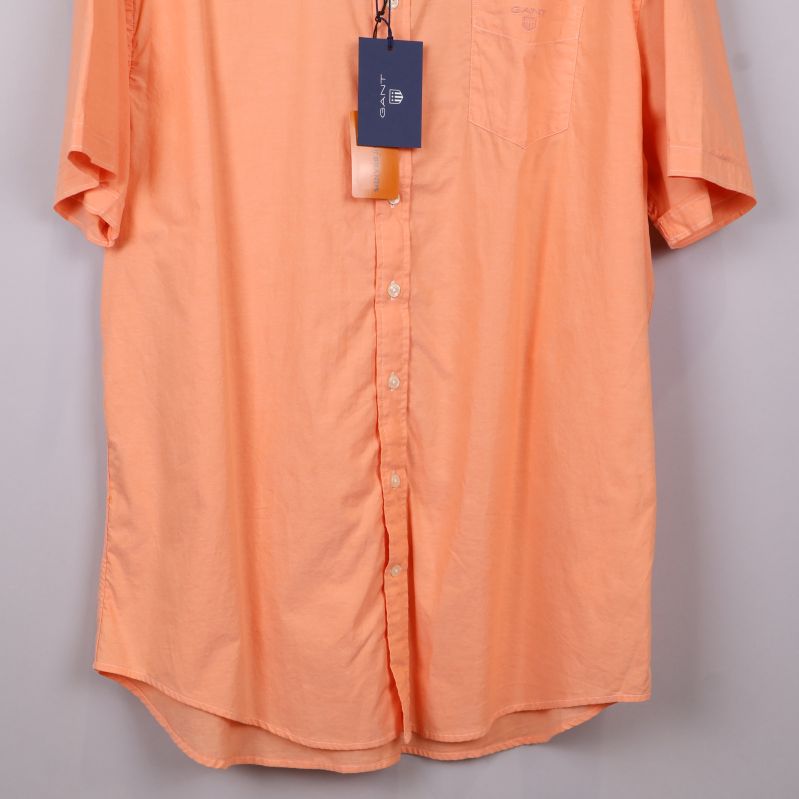 Närbild nedre delen av aprikos skjorta och knappar